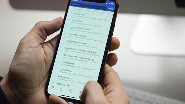 Close up of a man holding an iPhone